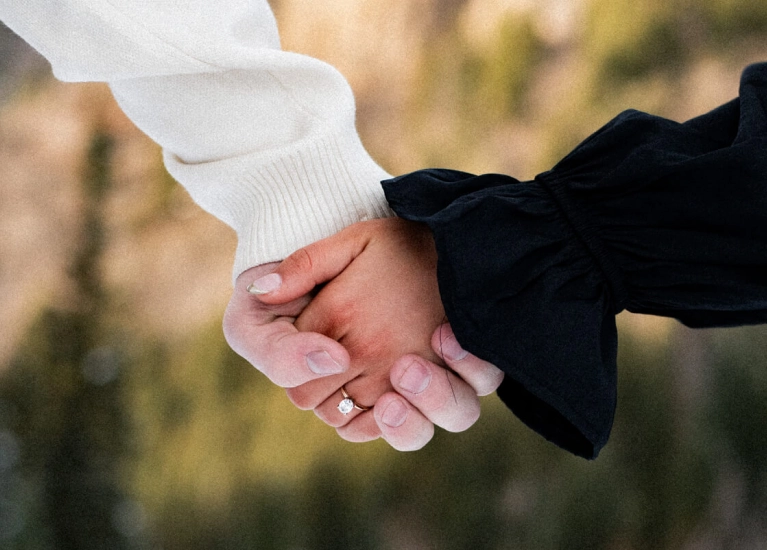 Close-up of an engaged couple holding hands outdoors during winter